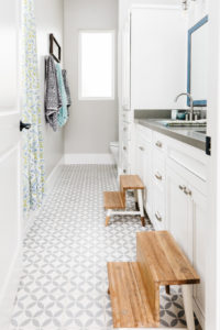 Kids bathroom with cement tile floor and blue mirrors